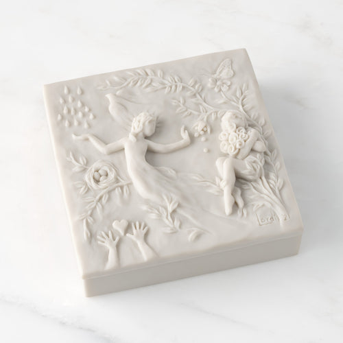Closed white resin box; lid carved with figural and organic imagery