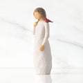 Front view of standing figure in cream dress with cardinal red bird perched on shoulder