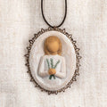 Oval bas-relief carving of figure holding sprig of rosemary, edged in pierced-metal filigree with brown elastic ornament loop