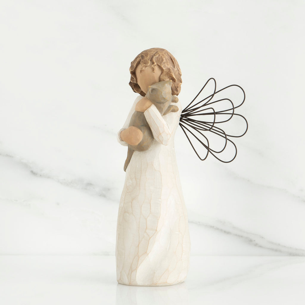 Small brunette angel figurine in white dress holding golden cat