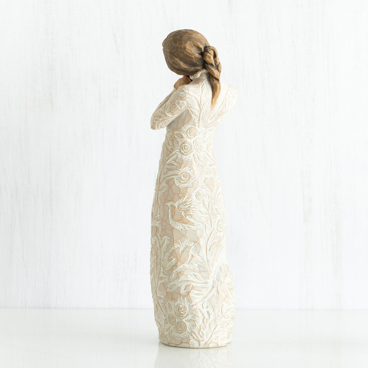 Side view of younger girl brunette figurine wearing white dress facing the other side