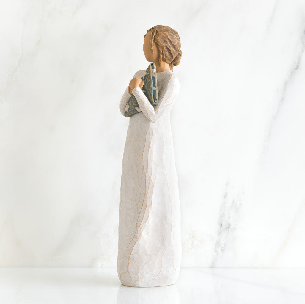 Side view of brunette girl figurine in white dress holding triangle figurine