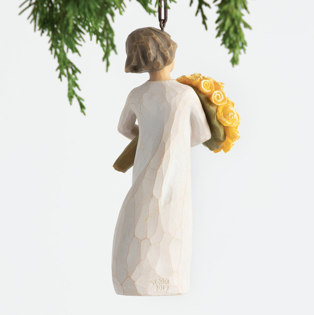 Back view, female figurine in cream dress, holding large bouquet of yellow roses. Hook and loop affixed to figure's head