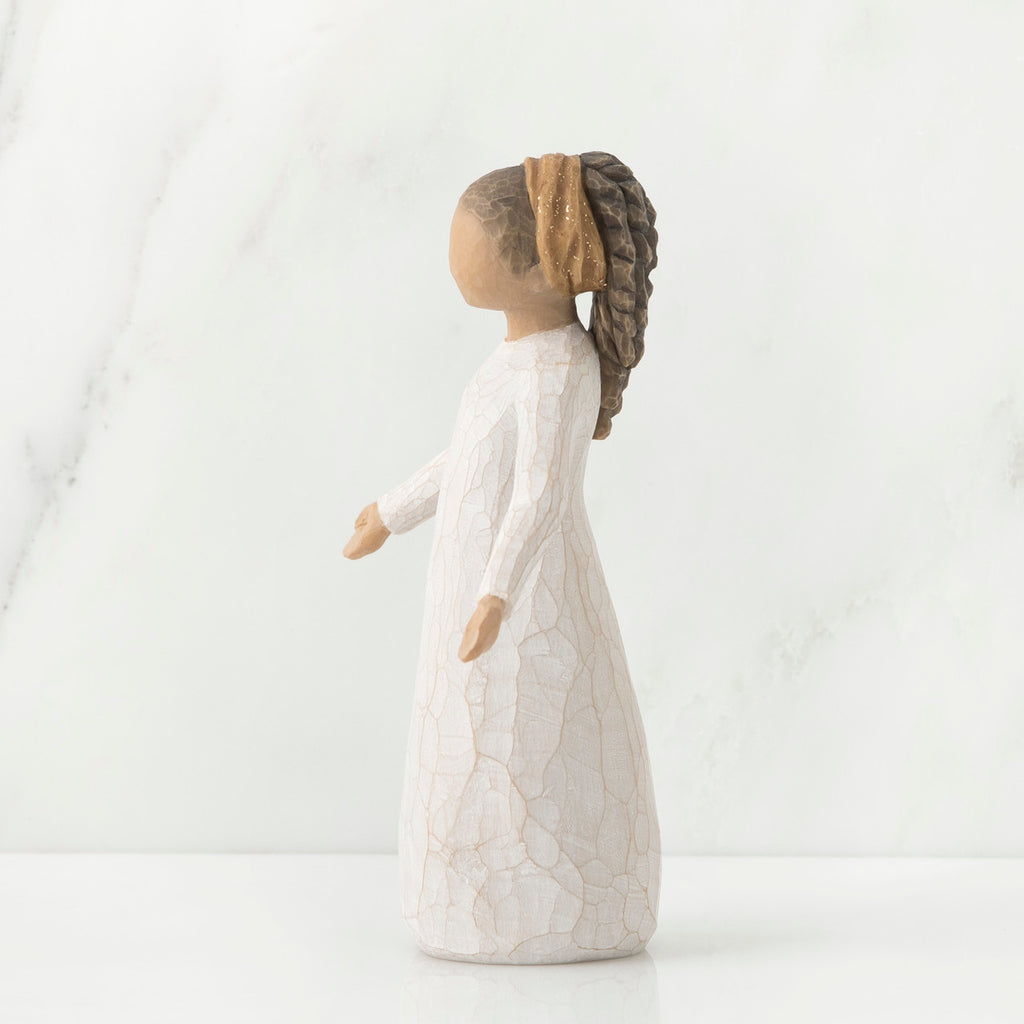 Side view of brunette girl figurine with braided ponytail wearing white dress standing up