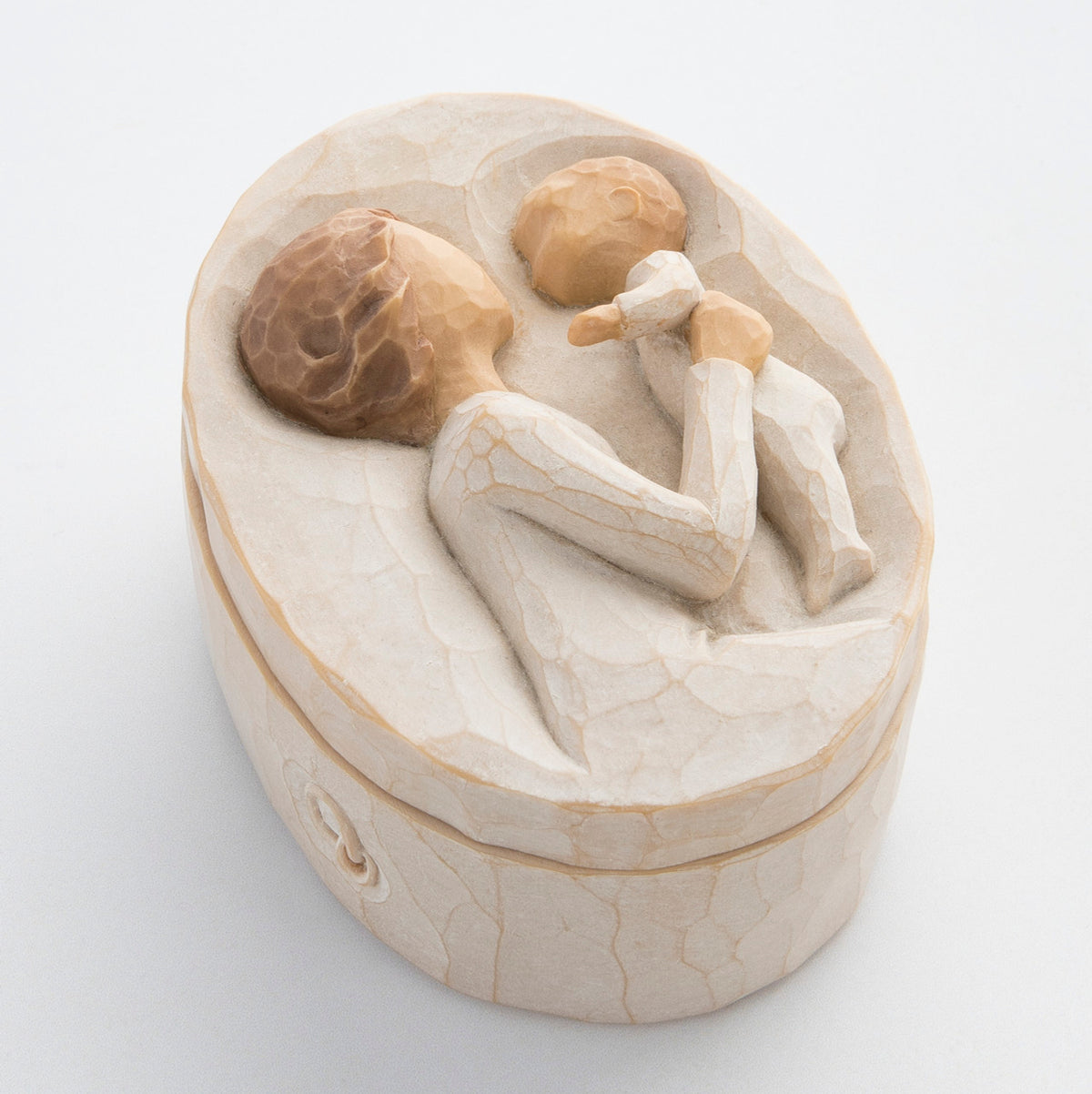 Small cream box with carved in image of brunette girl figurine holding up baby