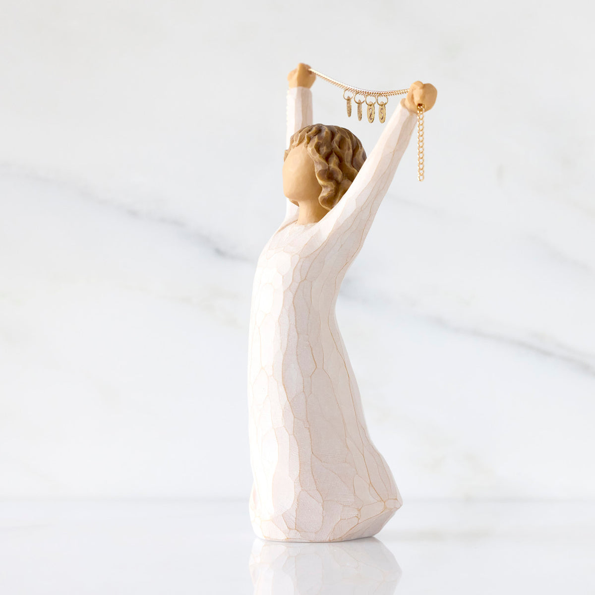 Willow Tree Courage 2025, 6”h hand-painted standing figure in cream dress holding aloft a gold chain with 2025 etched on gold medallions