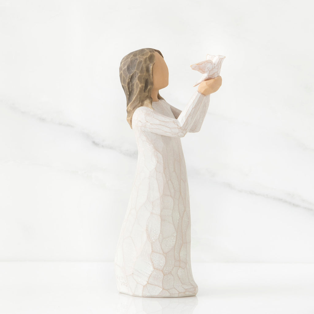 Side view of brunette woman in white dress holding up white bird