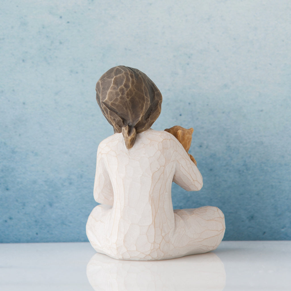 Small brunette girl in white facing away from the front towards the blue wall