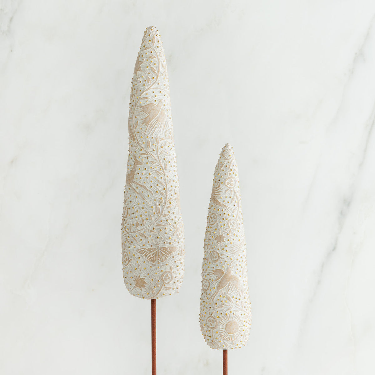 Set of two white tree figurines side by side