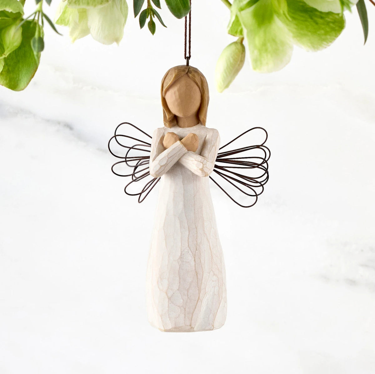 Figure in cream dress with wire wings and arms crossed in front of chest, ornament loop fixed to figure's head