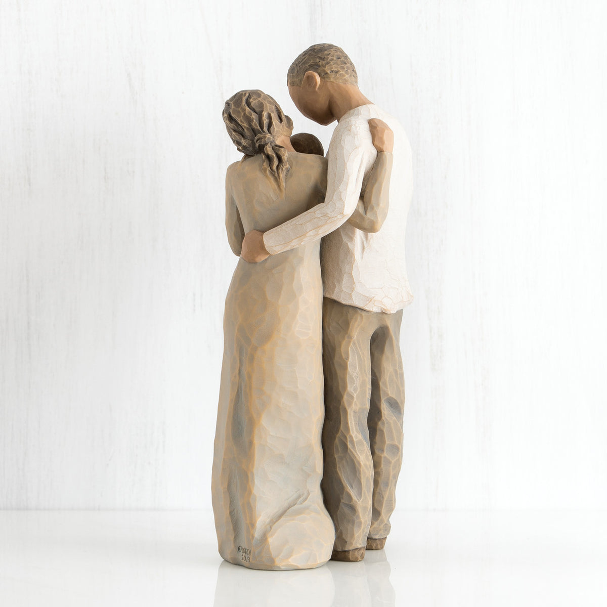 Back view of man and woman figurines hugging one another