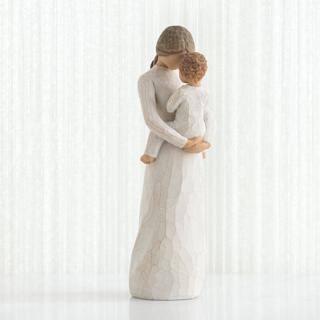 Woman figurine in white dress holding small child