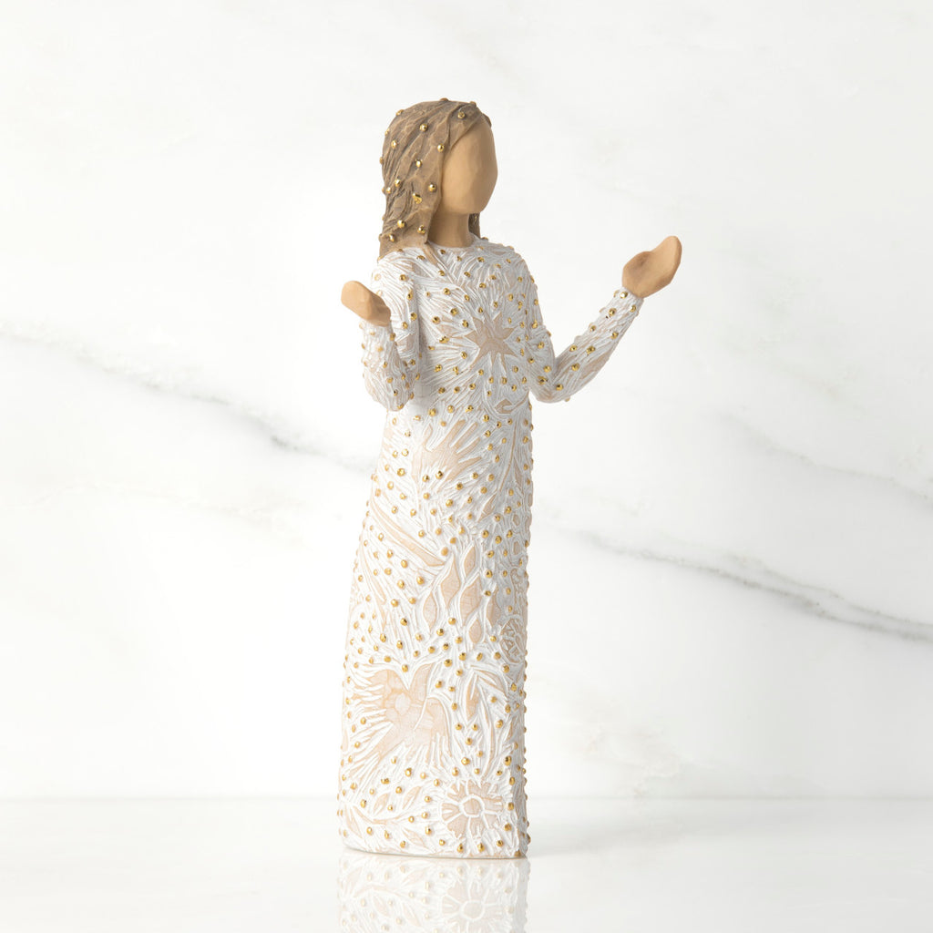 Side view of brunette woman figurine in white dress with gold dots holding her hands up