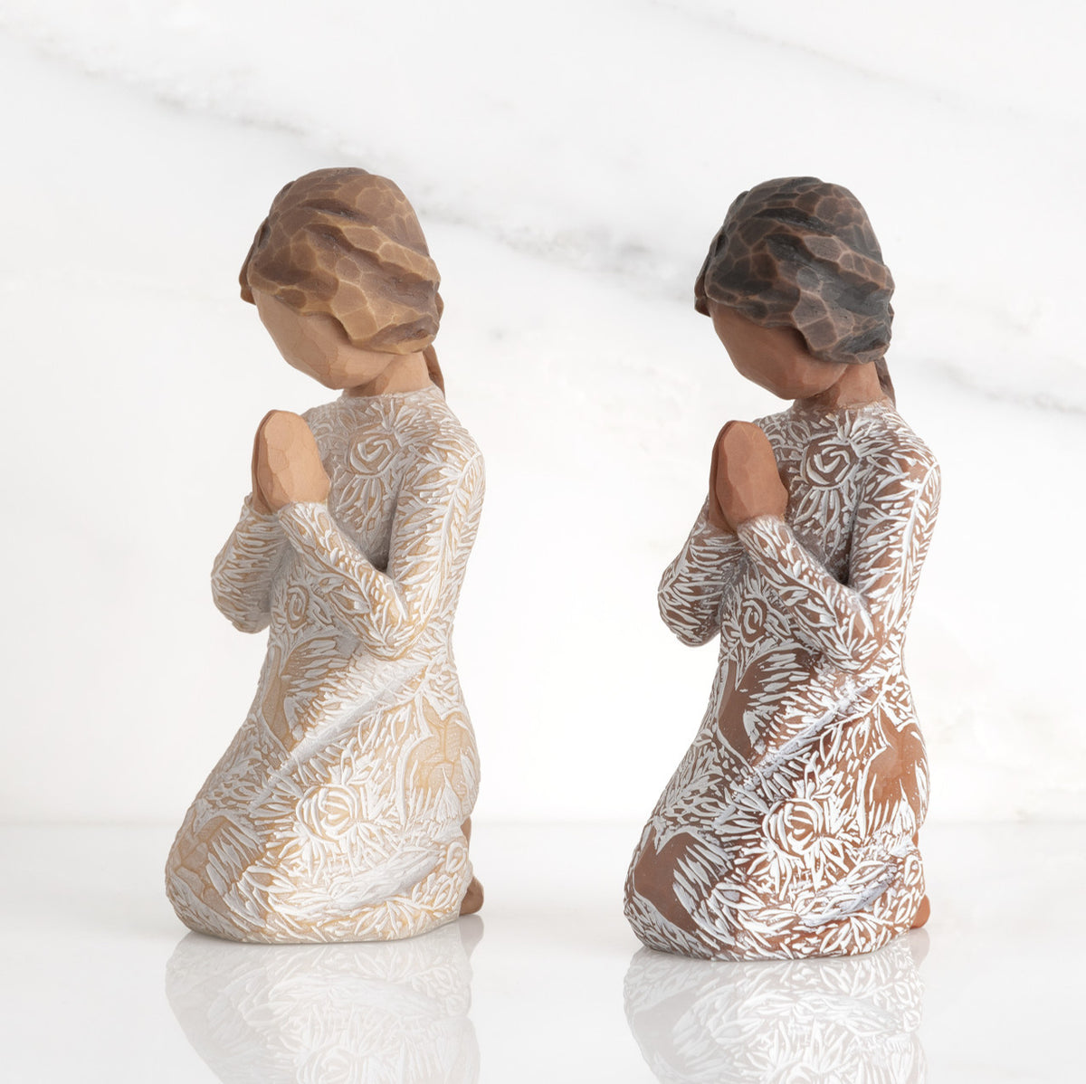 Lighter & Darker skin Kneeling figures, hands in position of prayer or meditation in cream dress carved with icons of nature, lighter and darker skin versions