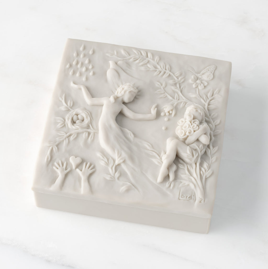 Closed white resin square box; lid carved with figural and organic imagery