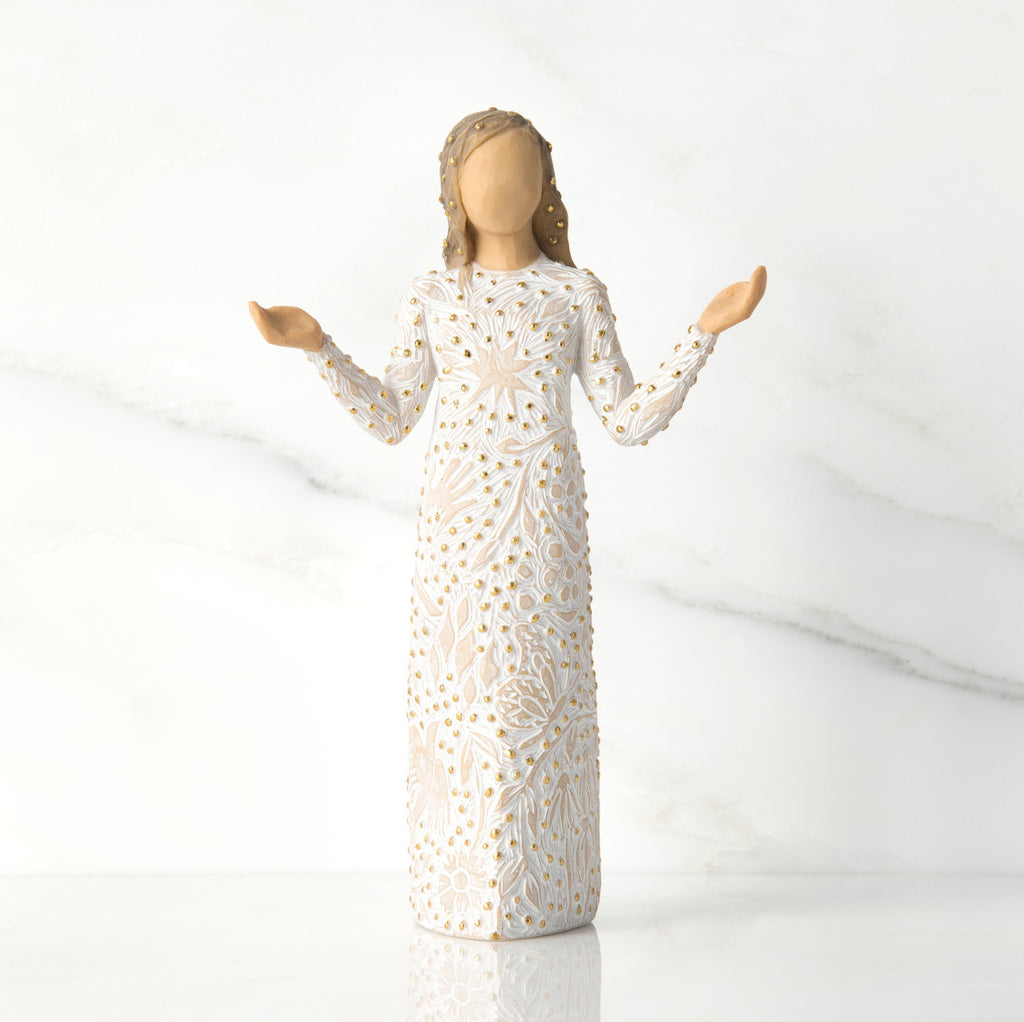 Front view of brunette girl figurine in white dress with gold dots holding her hands to the side