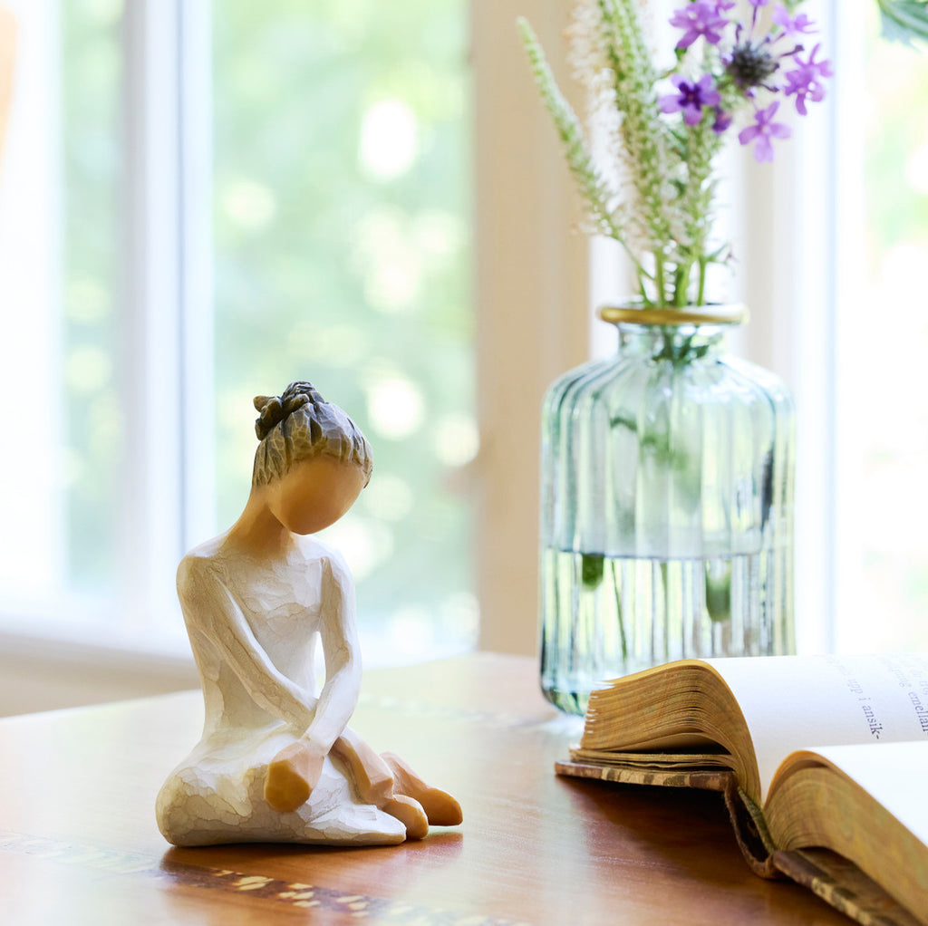 Willow Tree Serenity, 3.5”h hand-painted seated figure in cream dress, arms crossed in balletic pose, on table by window