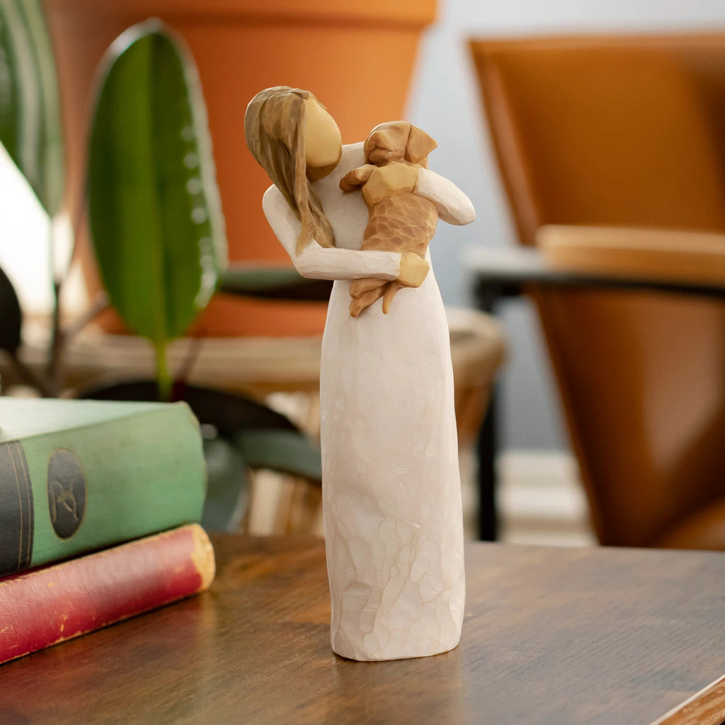 Willow Tree Adorable You (golden dog), 7.5”h hand-painted standing resin figure in cream dress, holding puppy, on wooden table